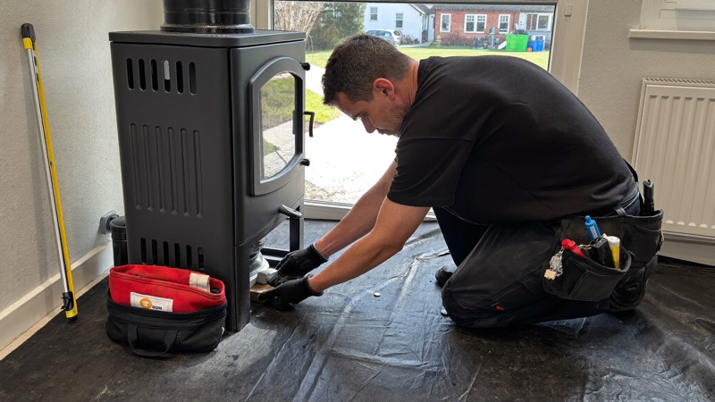 Installateur raccordant le conduit d’un poêle à granulés