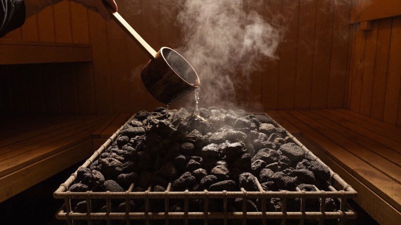 Poêle à pierres d’un sauna traditionnel et vapeur qui monte