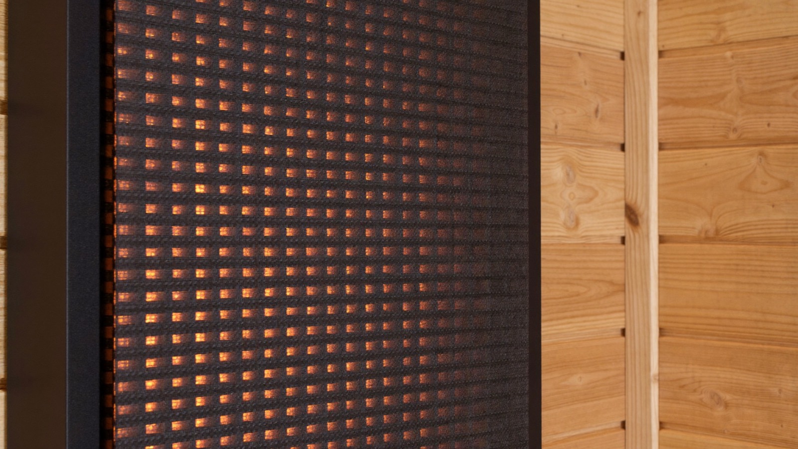 Gros plan sur la trame carbone d’un panneau chauffant infrarouge de sauna